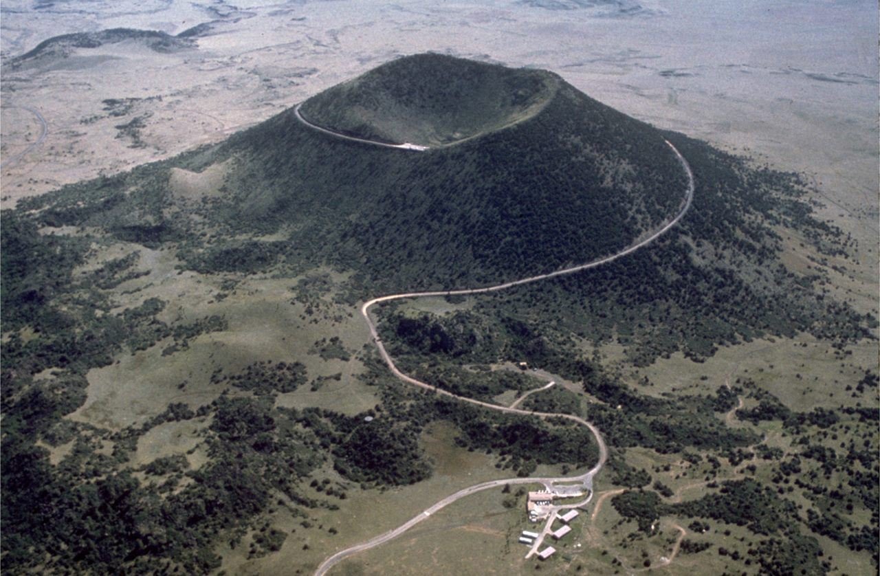 View of cinder cone volcano and the road leading to the top of the volcano as seen from the air.