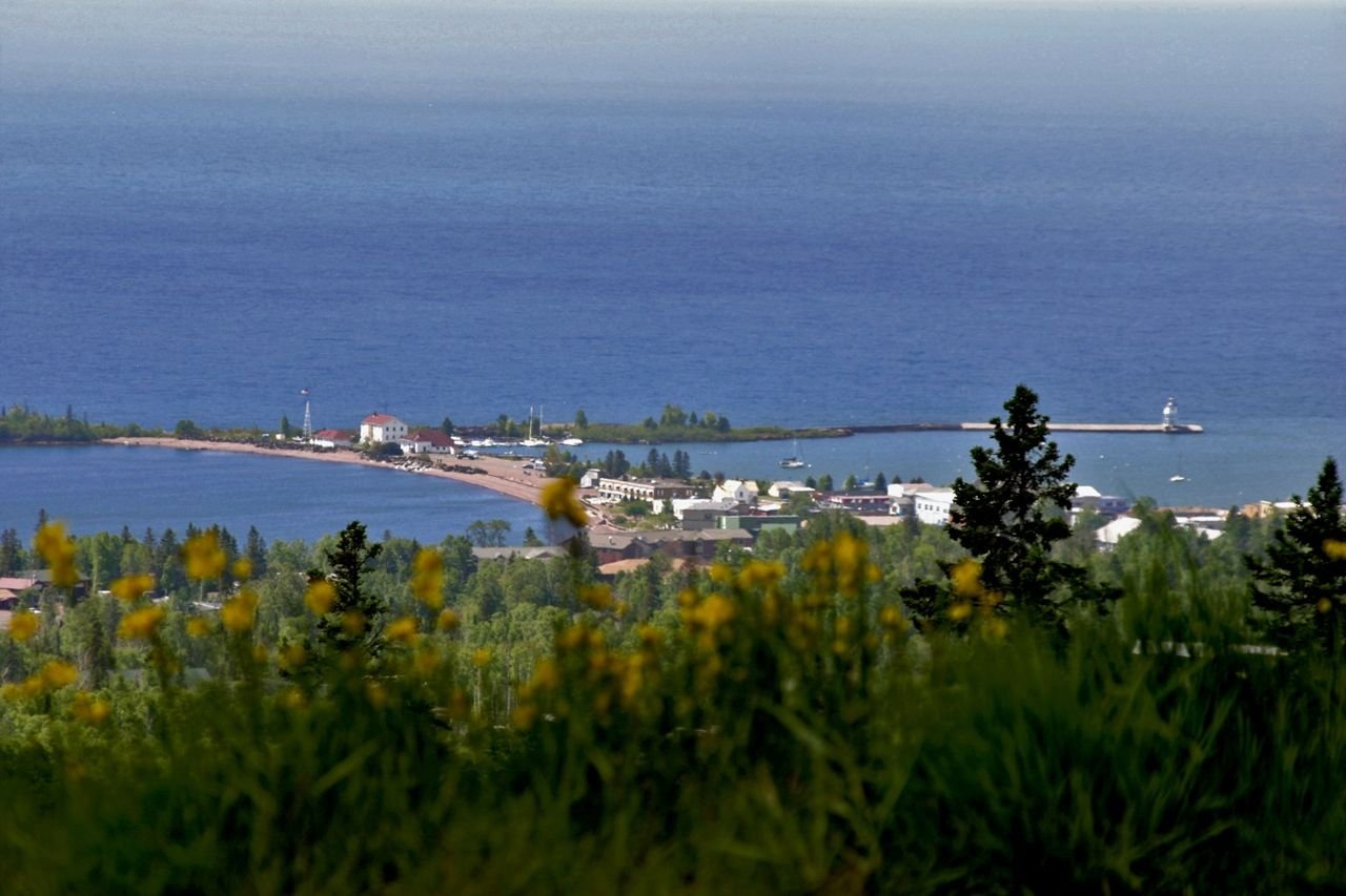 The small town of Grand Marais (population 1100) lies 1000 feet below this overlook perched on a steep hillside. The natural and man-made breakwaters and two lighthouses of Grand Marais gracefully embrace the entrance to the harbor. The deep blue of Lake Superior makes up the background.